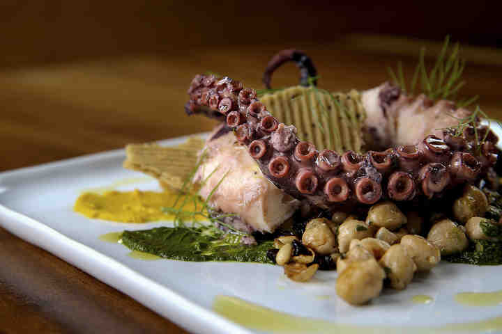 Octopus, served hot, featuring chickpea, currants pine puts, salsa verde and smoked tomato at Woodhouse Kitchen and Bar in Mason.   (Kareem Elgazzar / The Cincinnati Enquirer)